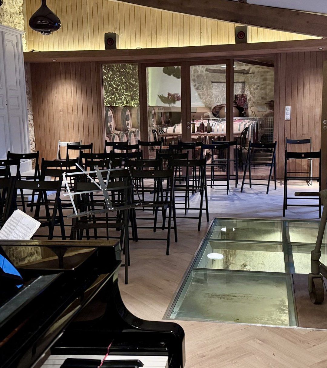 Die Salle de Dégustation, für ein Konzert bestuhlt, mit Flügel und Glasboden über dem Keller